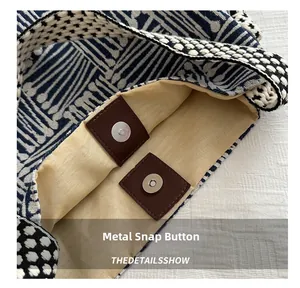 Close-up of geometric woven tote bag featuring a magnetic snap button on leather patch