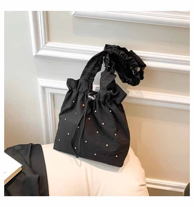 Detail of black drawstring tote bag featuring silver rhinestones and pleated handle