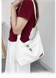 Detail of white nylon tote bag with multiple zippers and brown fashion leather patch