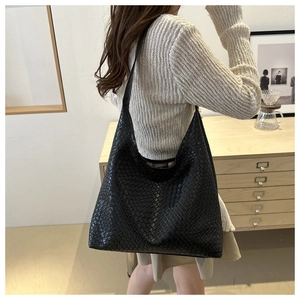Detail of a black woven leather hobo bag showing the intricate intrecciato pattern and texture