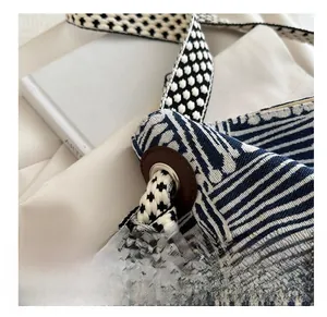 Close-up of bohemian woven tote bag showing geometric patterns and leather strap detail