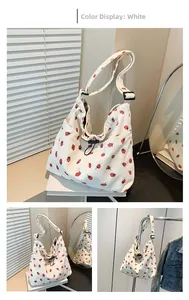 White corduroy tote bag featuring red strawberry patterns with adjustable black strap