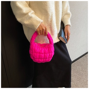 Close-up of bright pink quilted bubble bag showing its puffy texture and handheld handle