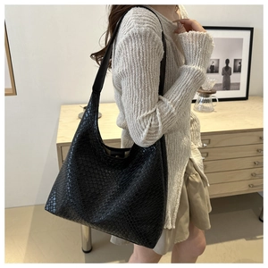 Detail of black woven Hobo shoulder bag with elegant texture and spacious interior
