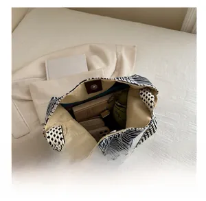 Top view of large canvas tote bag interior showing capacity for umbrella and books