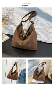 Detail of brown corduroy tote bag with strawberry print and adjustable strap feature