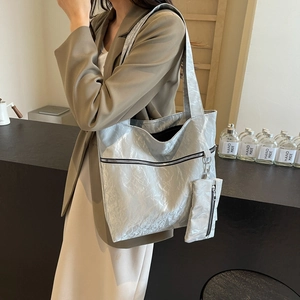 Large silver tote bag with metallic crinkle texture and matching mini pouch for women
