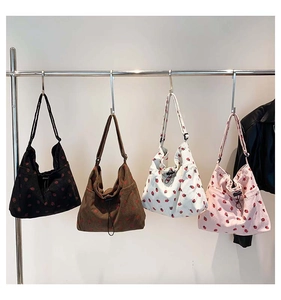 Detailed view of corduroy tote bags with strawberry patterns in four different colors
