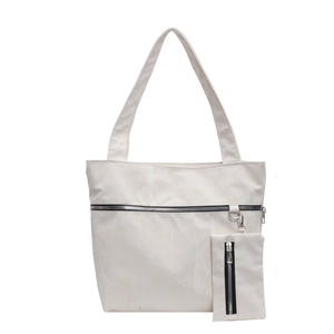 Minimalist white nylon tote bag with front zipper pocket and matching small pouch