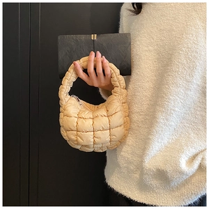 Detailed close-up of light yellow quilted cloud mini handbag with puffed fiber texture