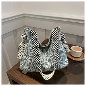 Detailed view of woven tote bag texture with geometric patterns and polka dot strap