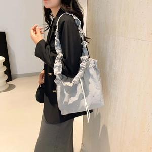 Gray pleated tote bag with ruffled strap and silver rivets for a minimalist summer look