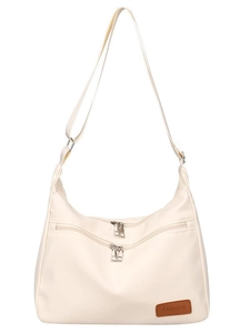 Minimalist cream nylon crossbody bag with double front zippers and adjustable strap