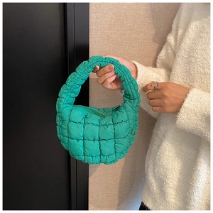 Detail of vibrant green quilted cloud bag with textured bubble fabric and zipper closure
