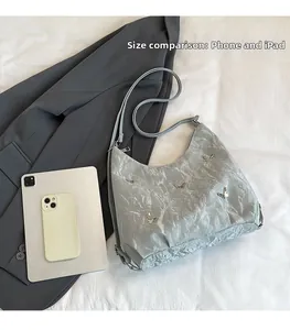 Comparaison de taille du sac à bandoulière gris métallisé avec iPad et smartphone