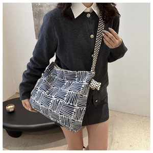 Detail of canvas tote bag with blue geometric patterns and wide shoulder strap