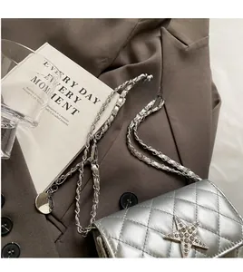 Détail du sac bandoulière argenté matelassé avec boucle étoile en cristal et chaîne