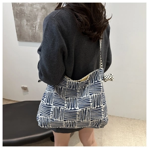 Detail view of large canvas tote bag featuring blue and white geometric line patterns