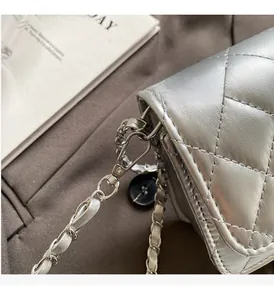 Gros plan sur un sac argenté matelassé avec bandoulière en chaîne et finitions de luxe