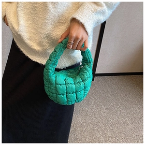 Close-up of bright green quilted puffy handbag with stylish crescent moon design