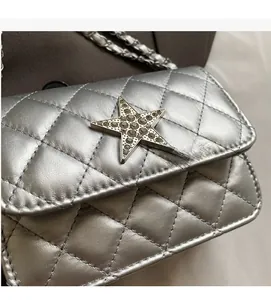 Détail du sac bandoulière argenté matelassé avec une grande boucle étoile en strass