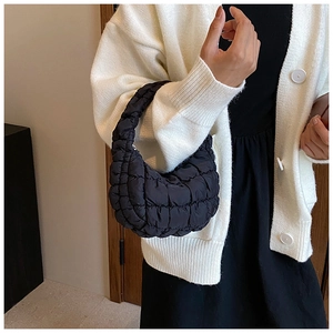 Close-up of black quilted cloud bag showing nylon texture and minimalist handle design