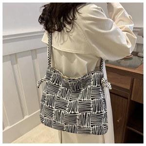 Detailed view of canvas tote bag with black and white artistic geometric line patterns