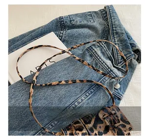 Détail du mini sac bandoulière à motif léopard avec bandoulière sur veste en jean