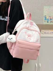 Detail of pink and white nylon backpack featuring a leather logo and cute bunny pendant