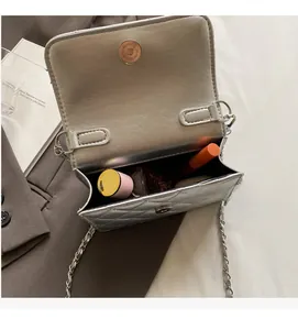 Vue détaillée du mini sac bandoulière argenté matelassé montrant l'espace intérieur