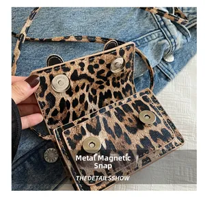 Détail de la boucle magnétique argentée sur un mini sac bandoulière à imprimé léopard