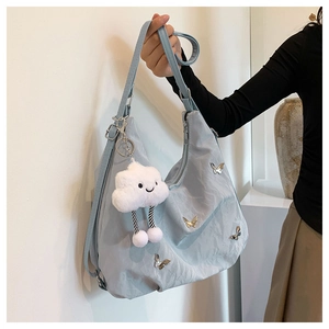 Détail du grand sac cabas bleu clair avec papillon argenté et peluche nuage incluse