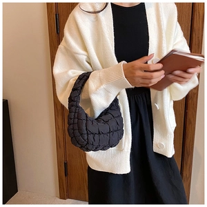 Close-up of black quilted cloud bag showing the pleated nylon fabric texture and handle