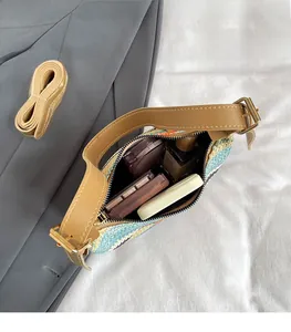 Detail view of woven shoulder bag showing spacious interior with cosmetics and strap
