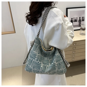 Detail of bohemian geometric tote bag with textured blue and white pattern and wide strap