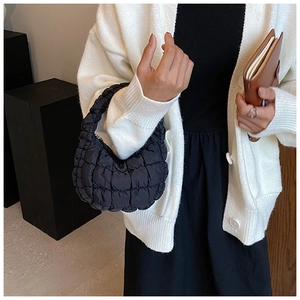 Close-up of black cloud bag with bubble quilted texture and integrated handle design