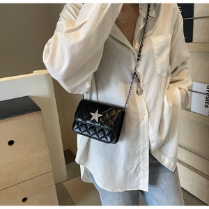 Détail du sac bandoulière matelassé noir avec strass en étoile et bandoulière chaîne