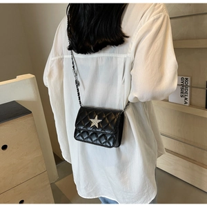 Vue détaillée d'un sac bandoulière matelassé noir orné d'une étoile en strass étincelante