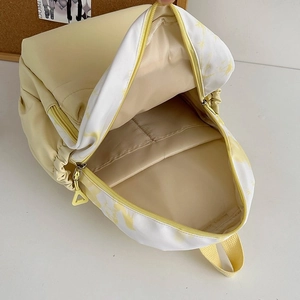 Detail view showing internal storage compartment and lining of the yellow nylon backpack