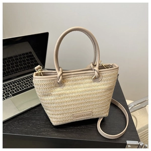 Détail de la texture tissée et du logo de mode sur le sac fourre-tout beige à anses