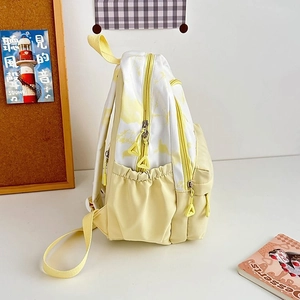Detail of yellow and white tie-dye nylon backpack with dual zippers and side pocket