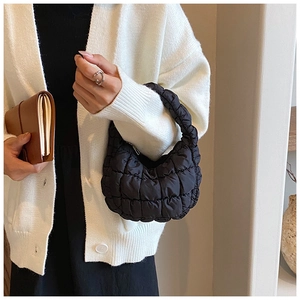 Detail showing a black quilted bubble cloud bag worn on the shoulder for a chic casual style