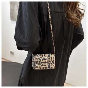 Détail du mini sac bandoulière léopard avec boucles vintage porté par un mannequin