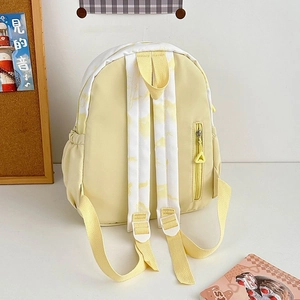 Detail view of tie-dye backpack back with padded straps and a hidden safety zipper pocket