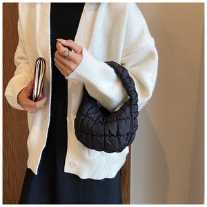 Detail of black quilted cloud bag showing the puffy square stitching and nylon texture