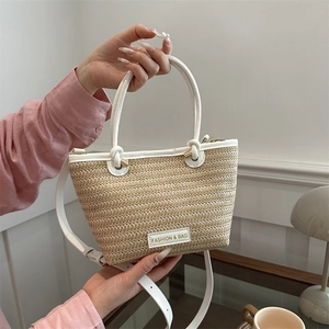 Détail du sac fourre-tout tissé avec anses en cuir blanc et bandoulière amovible