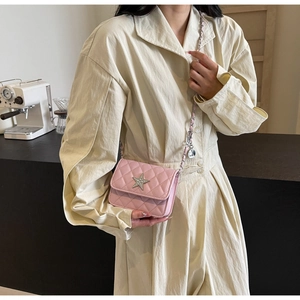 Détail du sac bandoulière rose matelassé avec étoile argentée et bandoulière chaîne
