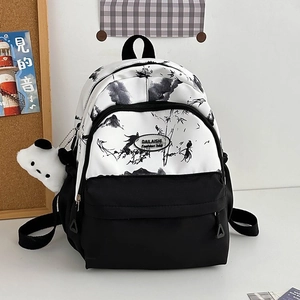 Close-up of minimalist nylon backpack with Chinese ink art and panda charm accessory