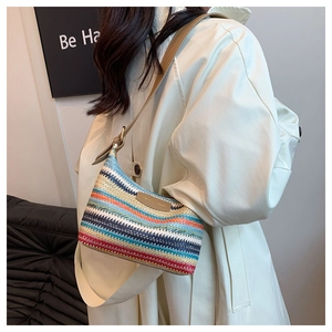 Detail of colorful rainbow woven shoulder bag with brown leather strap and logo patch