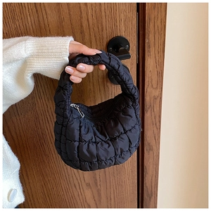 Detail of black quilted cloud bag with padded texture and silver zipper closure